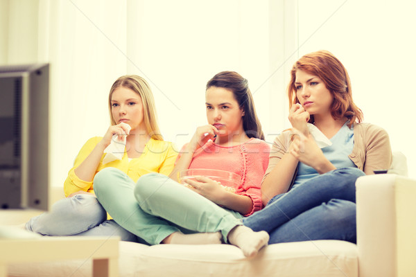 three sad teenage girl watching tv at home Stock photo © dolgachov