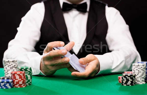 holdem dealer with playing cards and casino chips Stock photo © dolgachov