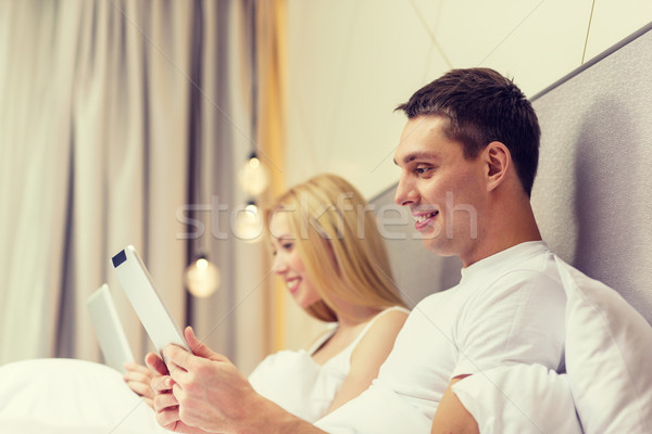 smiling couple in bed with tablet pc computers Stock photo © dolgachov