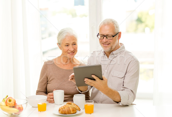 Stock photo: happy senior couple with tablet pc at home