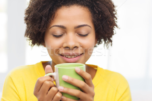 happy african american woman drinking from tea cup Stock photo © dolgachov