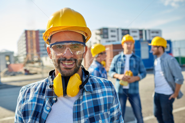 улыбаясь строителя наушники бизнеса здании Сток-фото © dolgachov