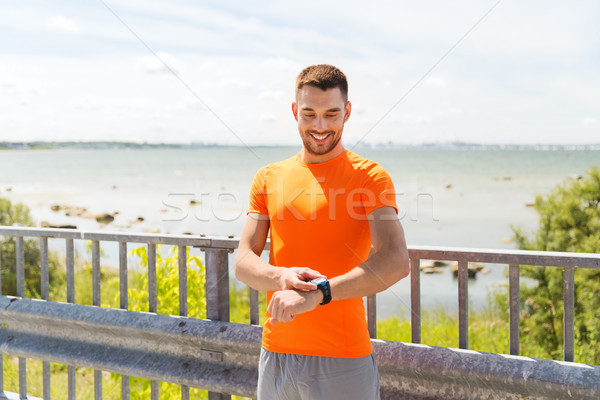 Sorridente moço inteligente beira-mar fitness Foto stock © dolgachov