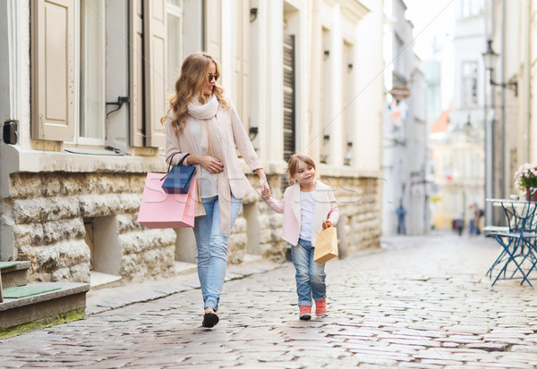 happy mother and child with shopping bags in city Stock photo © dolgachov