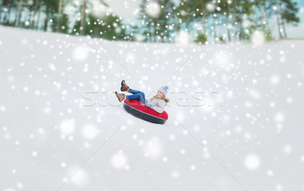 happy teenage girl sliding down on snow tube Stock photo © dolgachov