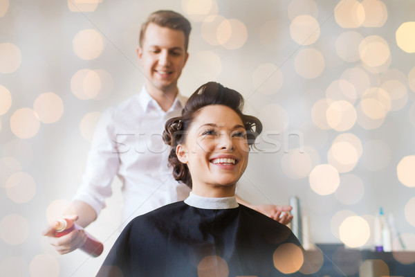 happy woman with stylist making hairdo at salon Stock photo © dolgachov
