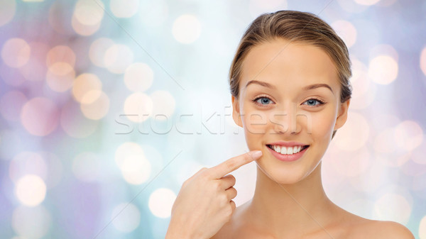 happy young woman pointing finger to her teeth Stock photo © dolgachov