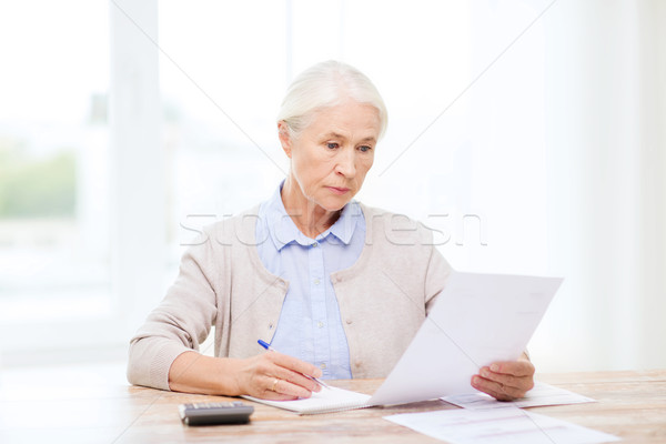 senior woman with papers and calculator at home Stock photo © dolgachov