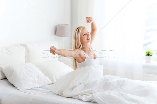 young woman stretching in bed after waking up Stock photo © dolgachov