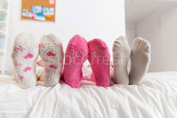 close up of women feet in socks on bed at home Stock photo © dolgachov