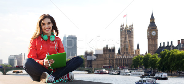 happy young woman with tablet pc and headphones Stock photo © dolgachov