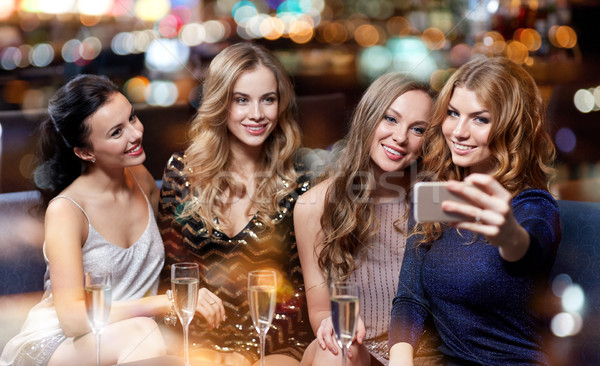 women with champagne taking selfie at night club Stock photo © dolgachov