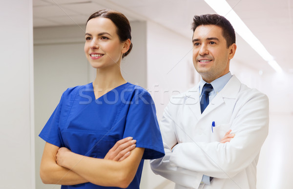 smiling doctor in white coat and nurse at hospital Stock photo © dolgachov