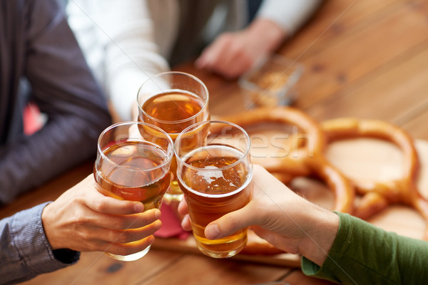 close up of hands clinking beer at bar or pub Stock photo © dolgachov