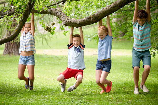 happy kids hanging on tree in summer park Stock photo © dolgachov