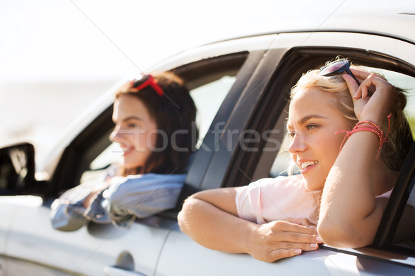 happy teenage girls or women in car at seaside Stock photo © dolgachov