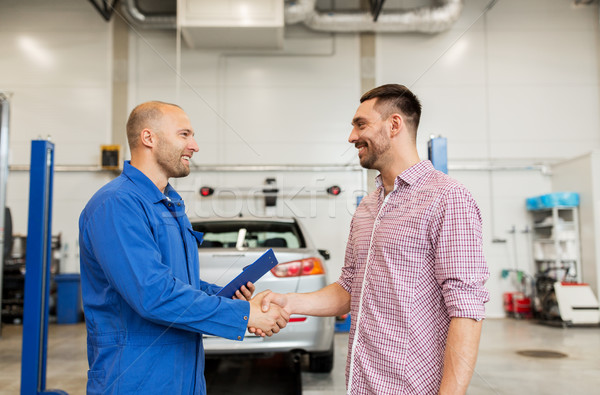 Stock photo: auto mechanic and man shaking hands at car shop