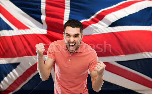 angry man showing fists over brittish flag Stock photo © dolgachov