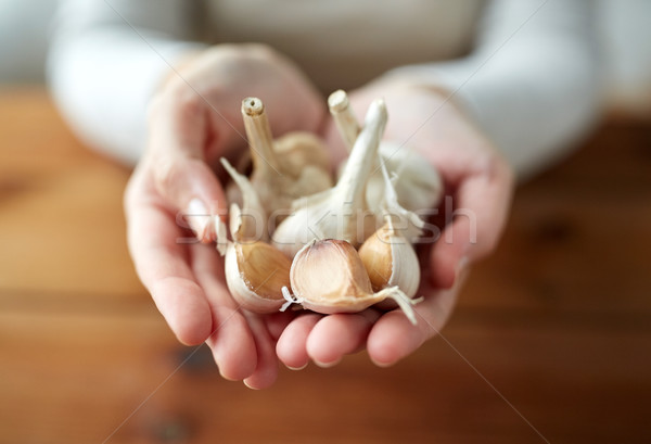 Stock photo: woman hands holding garlic