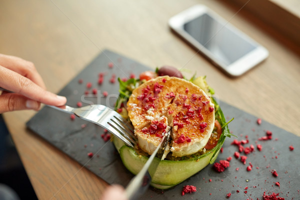 Mujer comer queso de cabra ensalada restaurante de comida culinario Foto stock © dolgachov