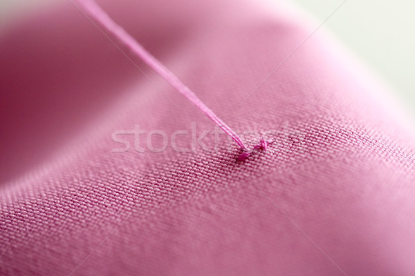thread with cross-stitch on pink fabric Stock photo © dolgachov