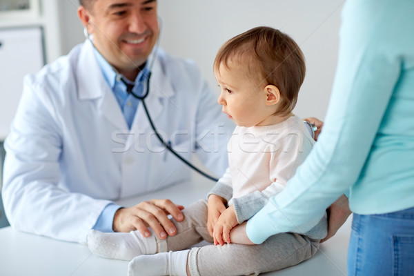 doctor with stethoscope listening baby at clinic Stock photo © dolgachov