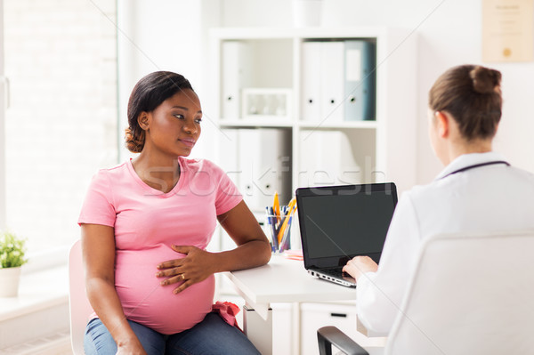 doctor with laptop and pregnant woman at clinic Stock photo © dolgachov
