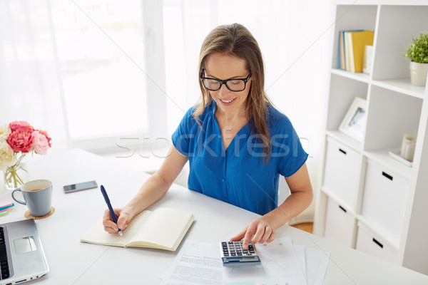 woman with calculator and notebook at office Stock photo © dolgachov