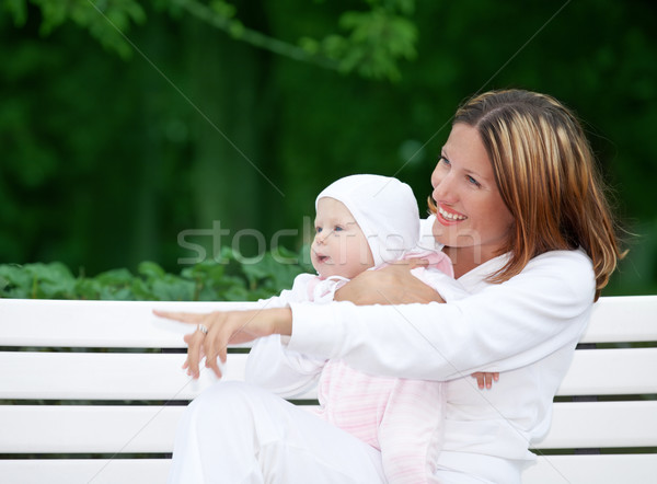 happy mother with baby on the bench Stock photo © dolgachov