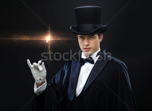 magician in top hat with magic wand showing trick Stock photo © dolgachov