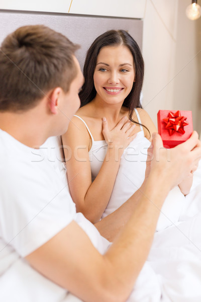 man giving woman little red gift box Stock photo © dolgachov