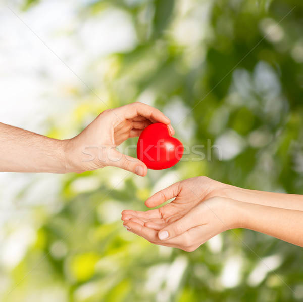 Stock photo: man hand giving red heart to woman