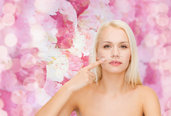 Stock photo: calm young woman pointing at her cheek