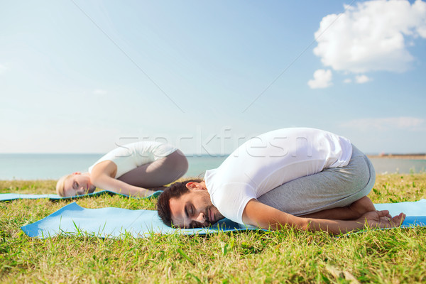 Sonriendo Pareja yoga aire libre fitness Foto stock © dolgachov