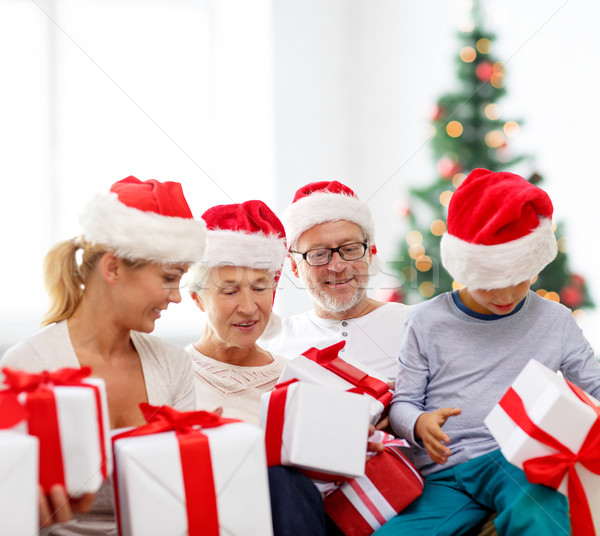 Stock photo: happy family in santa helper hats with gift boxes