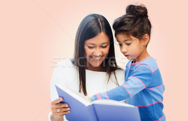 happy mother and daughter reading book Stock photo © dolgachov