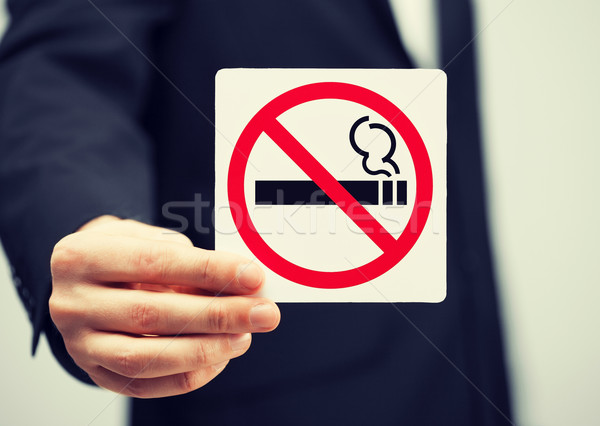man in suit holding no smoking sign Stock photo © dolgachov