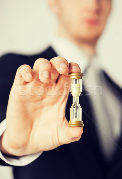 man hand holding hourglass Stock photo © dolgachov