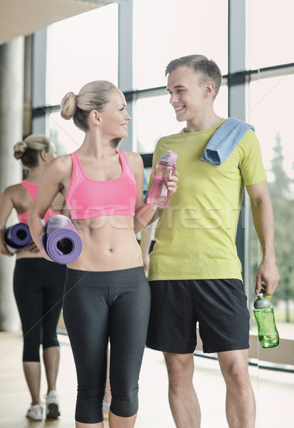 smiling couple with water bottles in gym Stock photo © dolgachov