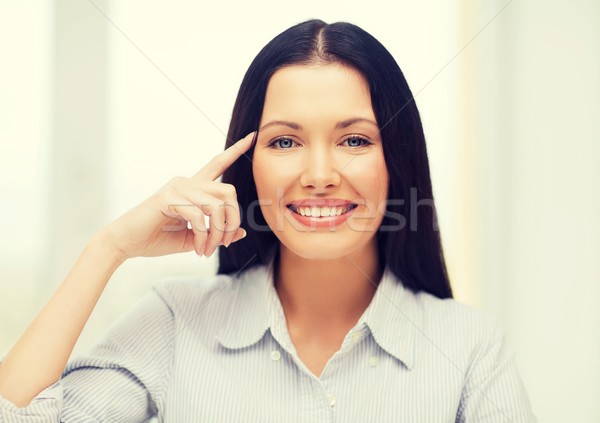 Stock photo: smiling woman pointing to imaginy glasses