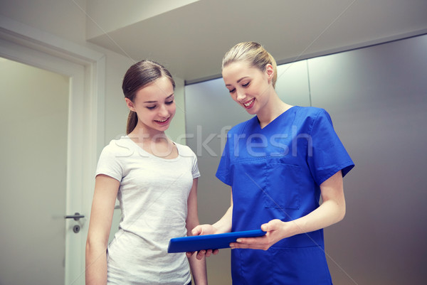 smiling nurse with tablet pc and girl at hospital Stock photo © dolgachov