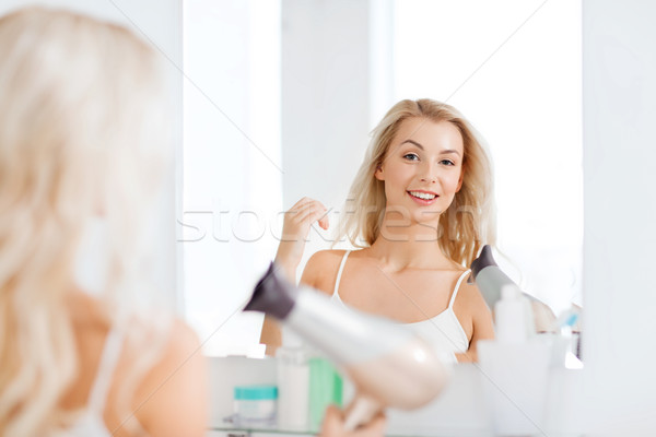 happy young woman with fan drying hair at bathroom Stock photo © dolgachov