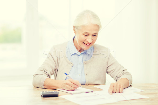senior woman with papers and calculator at home Stock photo © dolgachov