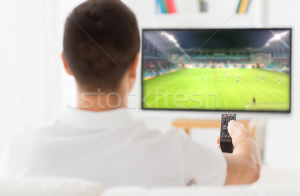 man watching football or soccer game on tv at home Stock photo © dolgachov