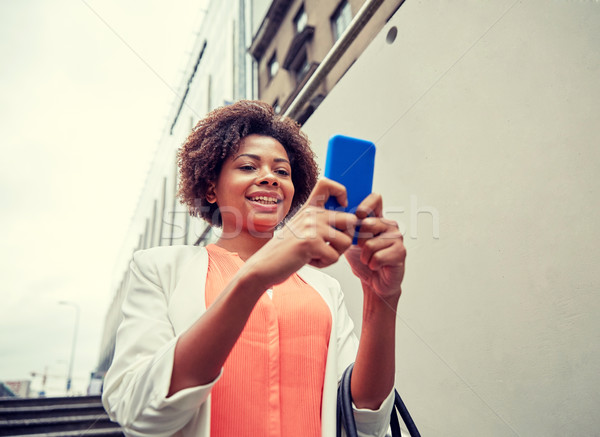 happy african woman with smartphone in city Stock photo © dolgachov