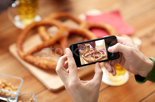 close up of hands picturing pretzel by smartphone Stock photo © dolgachov