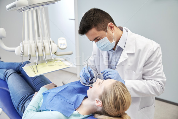 male dentist in mask checking female patient teeth Stock photo © dolgachov