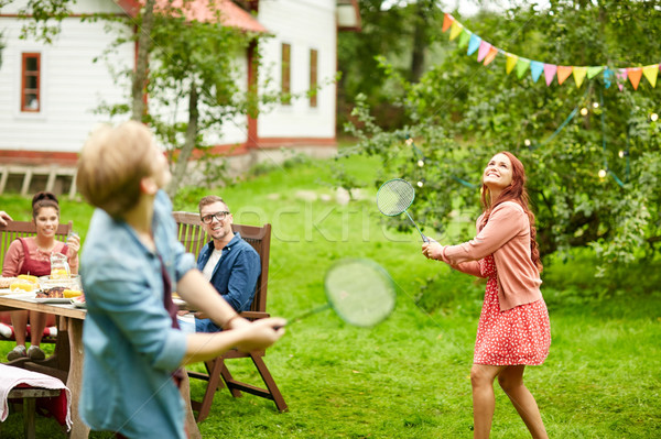 happy friends playing badminton at summer garden Stock photo © dolgachov