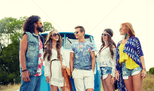 Stock photo: smiling young hippie friends over minivan car