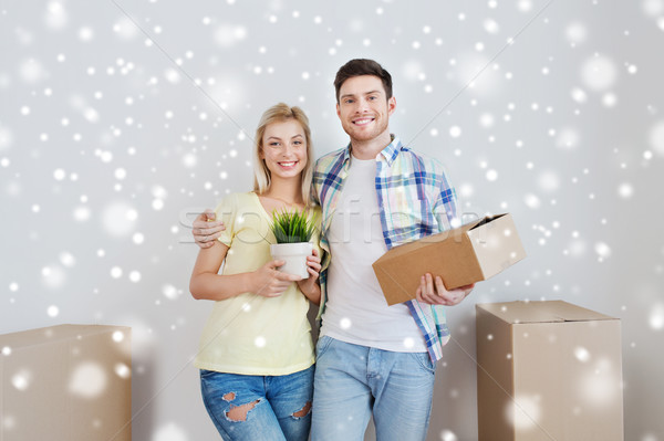 smiling couple with boxes moving to new home Stock photo © dolgachov